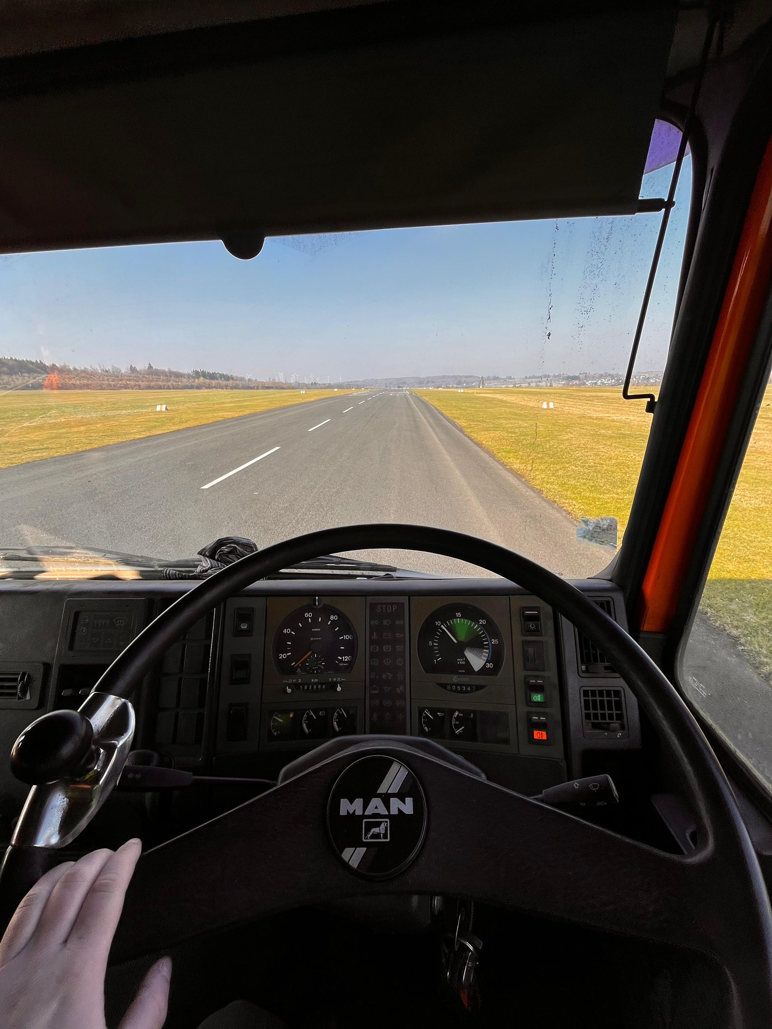 Blick aus der Kabine des Kehrwagens auf die Piste mit Mittellinie